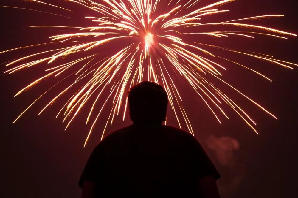 image of a silhouette of a person watching a firework display