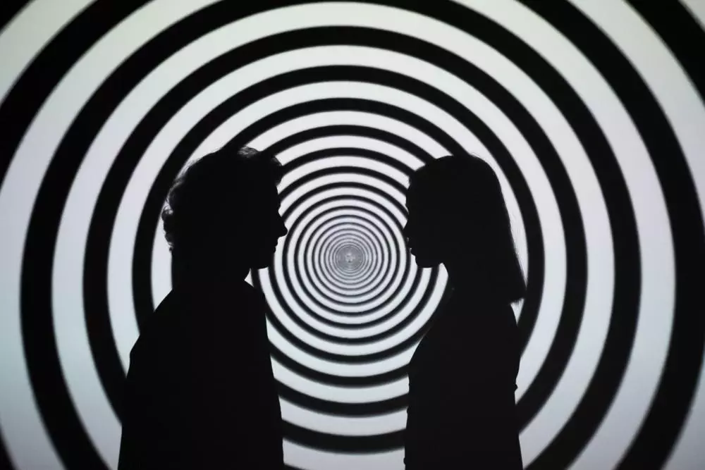 image of two silhouettes on a hypnotic background