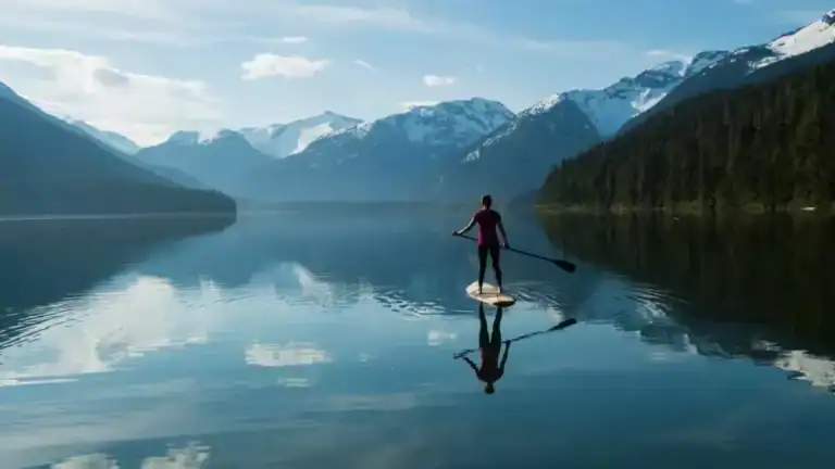 picture of a person with a paddle on a surfboard in a river to relieve pre-ketamine anxiety