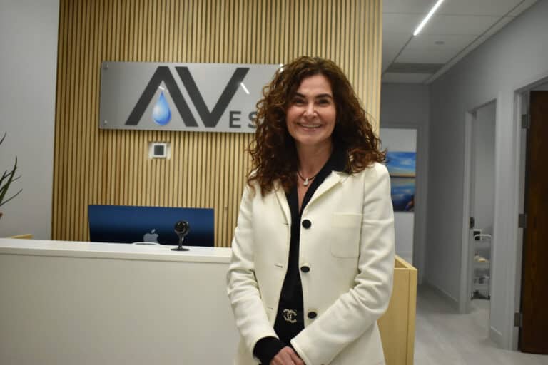 Dr. Ladan Eshkevari standing and smiling in front of desk at AVesta Ketamine Wellness in DC