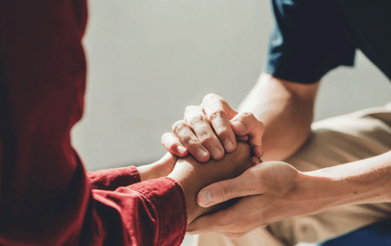 mental health provider holding patient's hands showing support after ketamine therapy