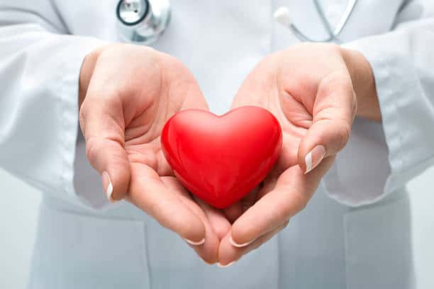 Female doctor with the stethoscope holding heart